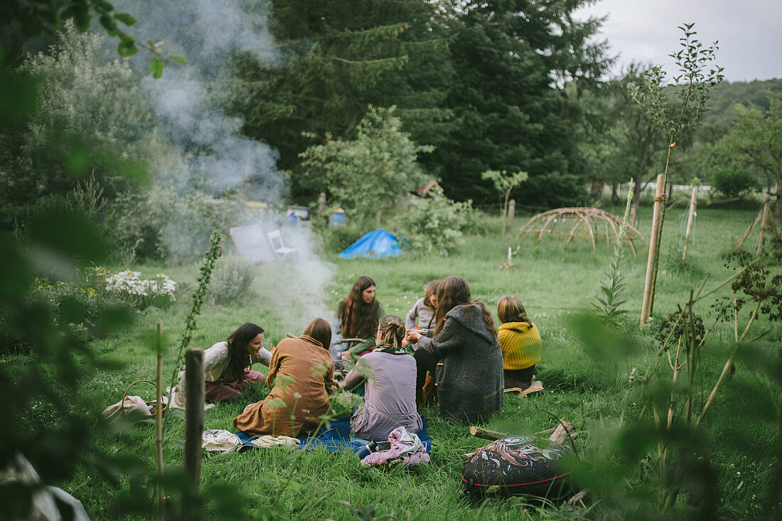 Frauenkreis um Feuer auf Sommerwiese, Fotografin: Tatyana Kronbichler